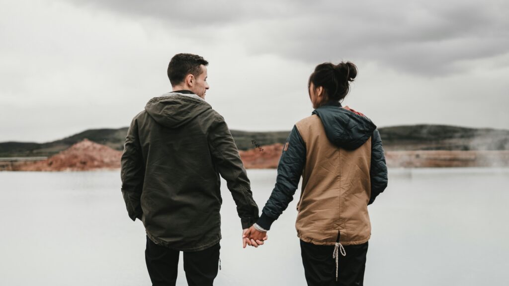 Couple walking hand in hand outdoors in a calm, natural setting