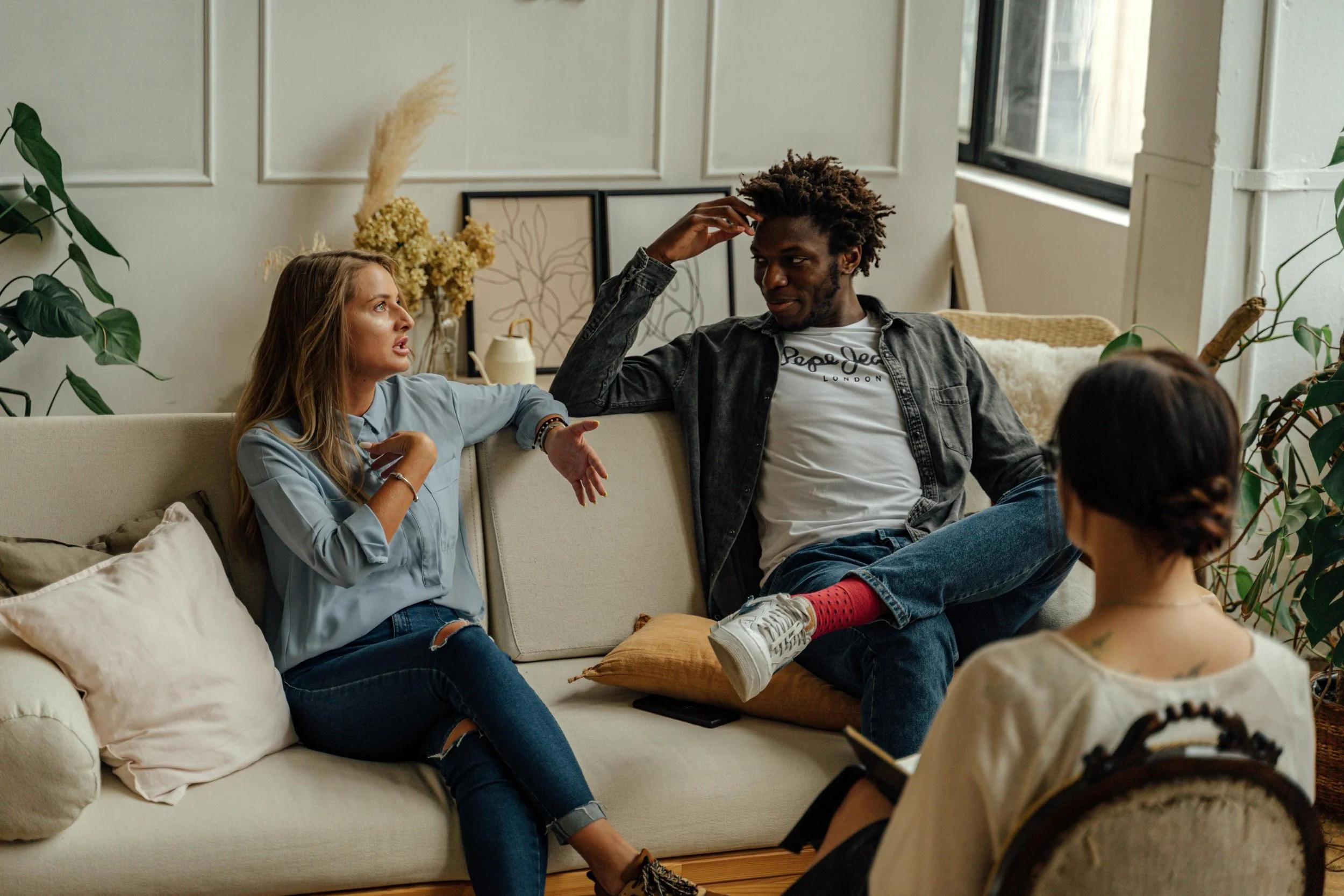 Couple sitting together on a sofa during couples therapy in Stockholm at Kindfulness