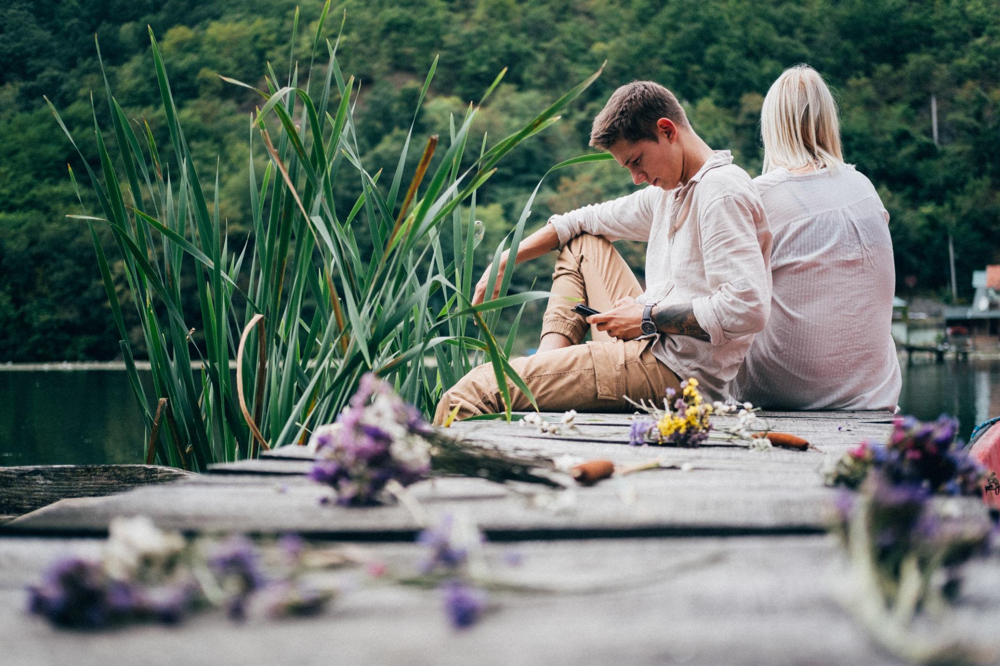 “Couple sitting together at home but feeling emotionally disconnected before starting couples therapy in Stockholm with Jivan Dios